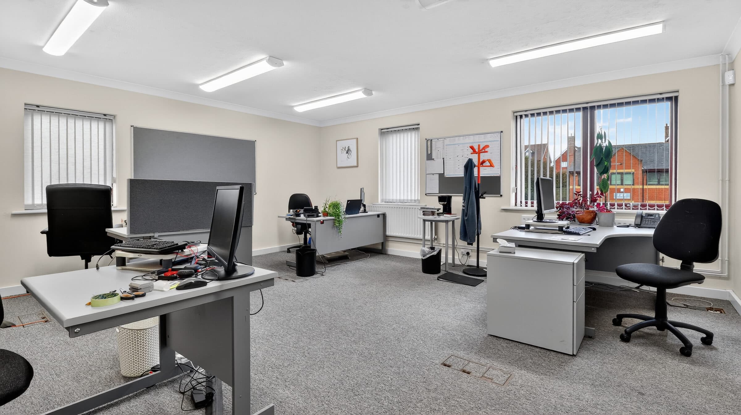 Bright office interior with desks and workstations, representing a busy estate agency.